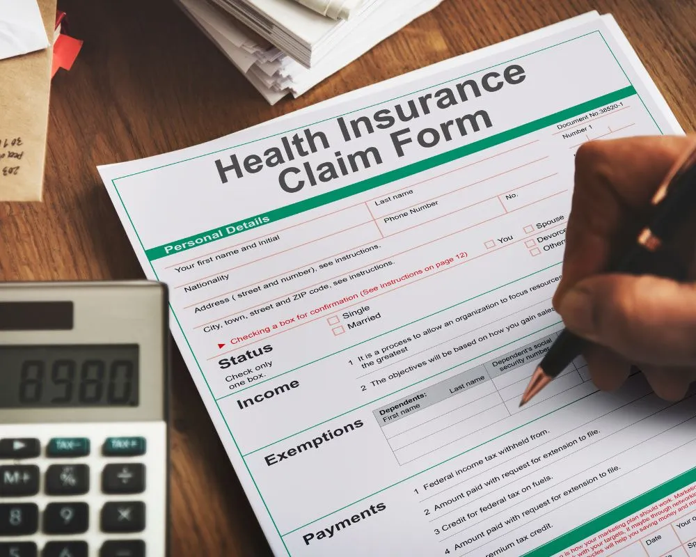 A close-up look of man filling the health insurance claim form